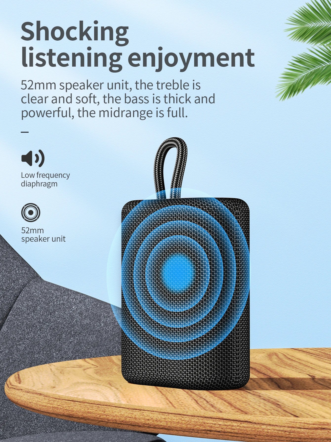 Black portable speaker with blue circular design on a wooden surface against a light blue background