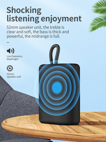 Black portable speaker with blue circular design on a wooden surface against a light blue background