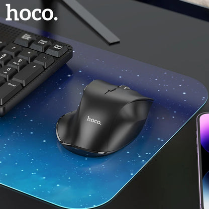 Black hoco. mouse on a starry mouse pad with keyboard and smartphone in the background