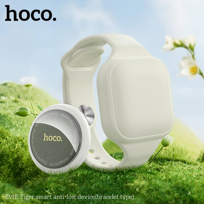 White smart anti-lost device with 'hoco.' branding on grass and flowers