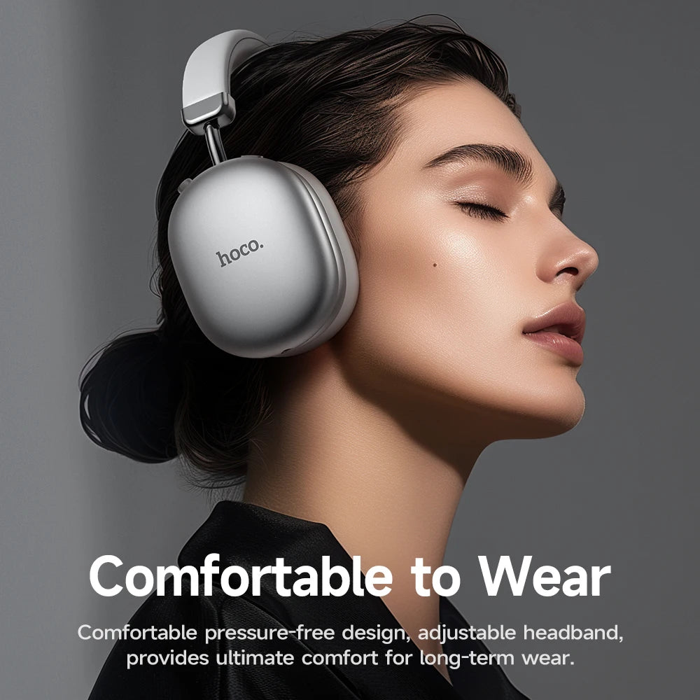 Woman wearing silver headphones with 'hoco.' branding on a gray background