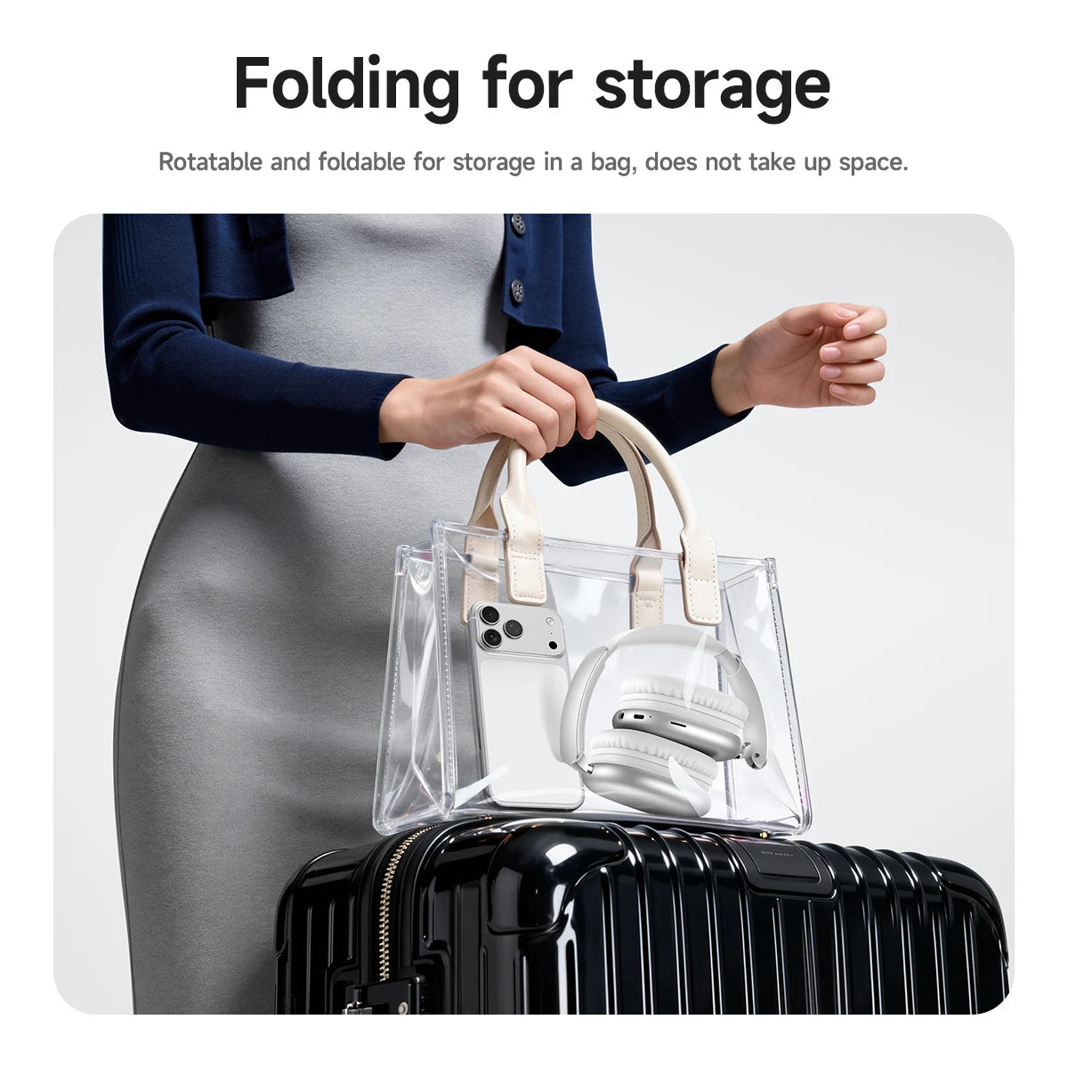 Person holding a clear handbag with a white shoe inside, over a black suitcase.