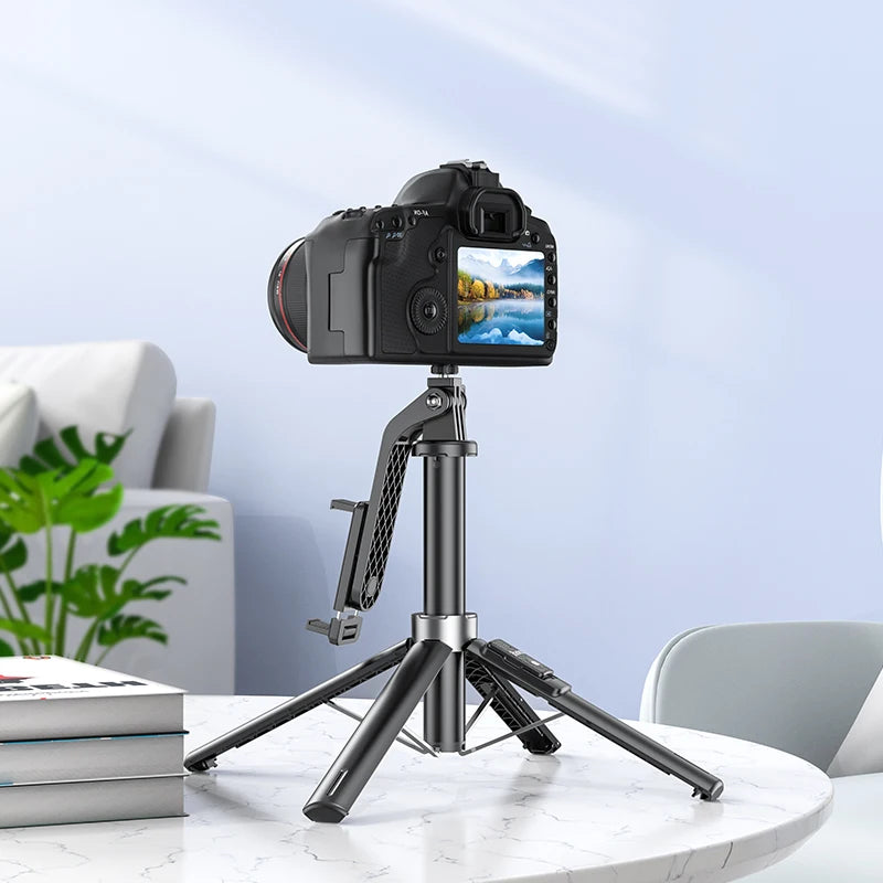 Camera on a tripod with a smartphone holder on a marble surface, with a blurred indoor background.