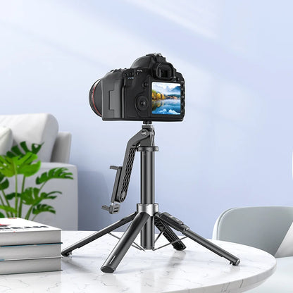 Camera on a tripod with a smartphone holder on a marble surface, with a blurred indoor background.