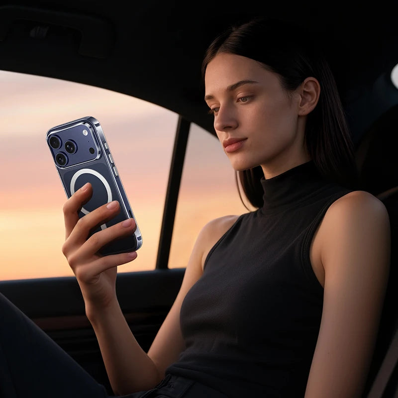Woman sitting in a car holding a smartphone with a sunset in the background