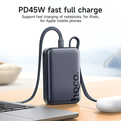 Hoco power bank with cable on a desk next to a laptop and mouse, with text about fast charging capabilities.