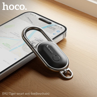 Smart anti-lost keychain with smartphone displaying app on wooden surface, featuring hoco brand.